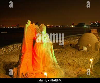 Sand-Skulpturen am Strand in Puerto Vallarta, Mexiko, mit Hotel Lichter im Hintergrund. Stockfoto