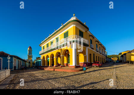 Zentrum von Trinidad Palacio Brunet, gelbe Palast mit blauen Himmel und die Kirche Convento de San Francisco de Asis, Straßenszene, Stockfoto