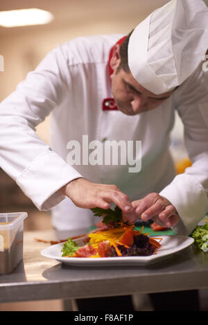 Koch in Hotelküche vorbereiten und dekorieren, Essen, köstliche Gemüse und Fleisch essen Abendessen Stockfoto
