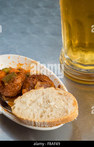Traditionelle spanische Fleischbällchen Tapa serviert mit einem Glas Bier Stockfoto
