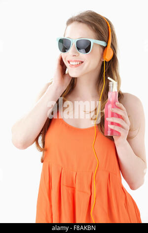 Junge Frau in orange ärmelloses Shirt mit einer Flasche Getränk Stockfoto