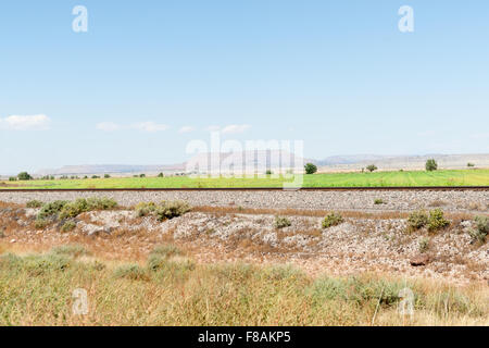 New Mexico Hochebenen Landschaften und Eisenbahn entlang der Route 66 mit entfernten Mesa Landanordnung. Stockfoto