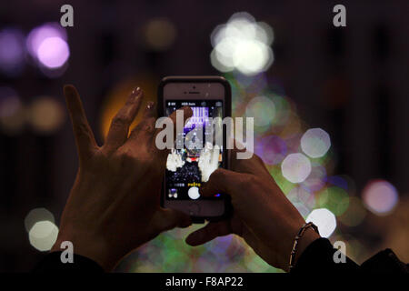 New York, New York, USA. 7. Dezember 2015. Besucher in New York City Rockefeller Center machen Sie Fotos von den riesigen Weihnachtsbaum, der in der Ferne sichtbar ist. Bildnachweis: Adam Stoltman/Alamy Live-Nachrichten Stockfoto