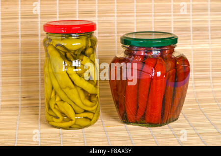Zwei Gläser mit marinierter Paprika auf Bambus materiellen Hintergrund Stockfoto