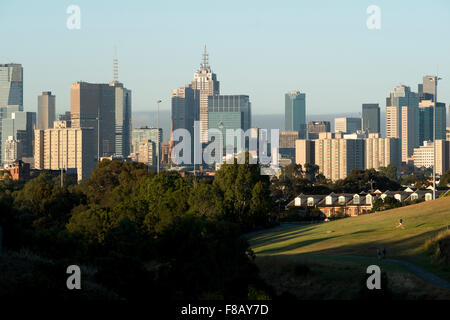 Ein Läufer übt auf die Clifton Hill Hall Reserve vor der Skyline von Melbourne. Stockfoto