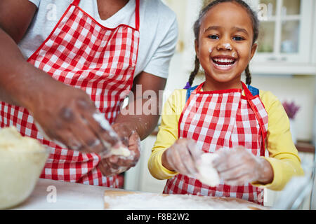 Glückliche kleine Mädchen, das Gebäck mit ihrem Vater in der Nähe von Stockfoto