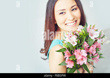 Lächelnde junge Frau mit Blumenstrauß Stockfoto