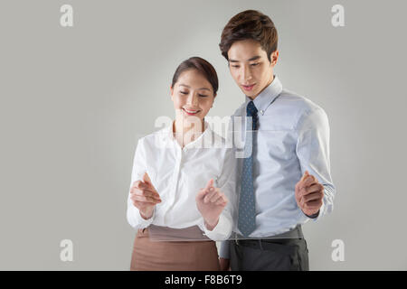 Mann und Frau in formalen Outfits mit touch-Screens und blickte mit einem Lächeln Stockfoto