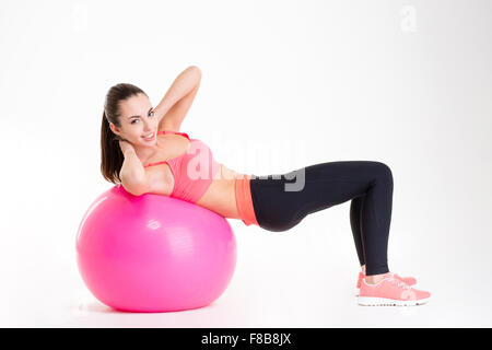 Fröhlich schöne Fitness-Mädchen training Bauchmuskeln mit Fitball isoliert auf weißem Hintergrund Stockfoto