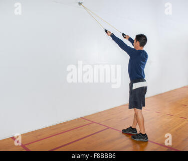 Mittleren Alter Mann Widerstand Band Übung für die Lats in Startposition auf beiden Beinen zu zeigen. Stockfoto