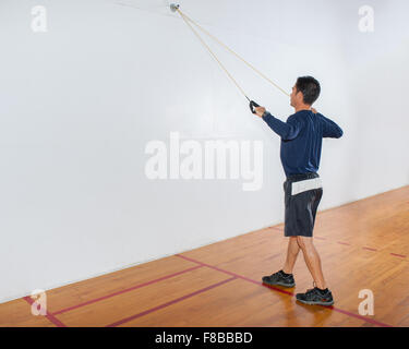 Mittleren Alter Mann Widerstand Band Übung für die Lats in Finish-Position zu zeigen. Stockfoto