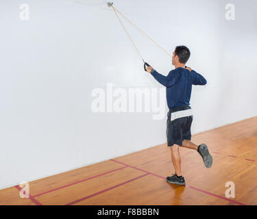 Mittleren Alter Mann zeigen Widerstand Band Übung für die Lats und Balance im Finish-Position. Stockfoto