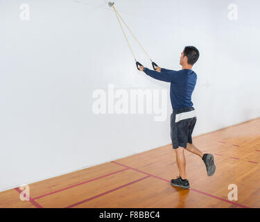 Mittleren Alter Mann zeigt Widerstand Band Übung für die Lats und Balance in Startposition. Stockfoto