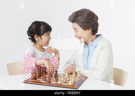 Großmutter und Enkelin Tisch sahen einander und spielen Schach Stockfoto
