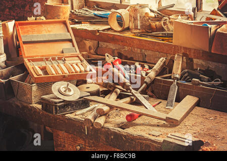 Retro-stilisierte alte Werkzeuge auf Holztisch in einer Tischlerei. Stockfoto