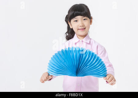 Mädchen mit Pony Tail Frisur in rosa Hemd holding Papiermodelle und öffnen Stockfoto