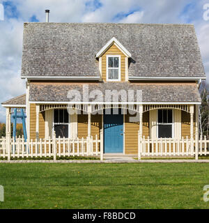 Eine kleine altmodische Altbau mit einem Lattenzaun. Stockfoto
