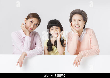 Junge Frau, junge Mädchen und senior Frau ruht ihre Arme auf einem weißen Raum mit ihren Kopf in die andere kopieren Stockfoto