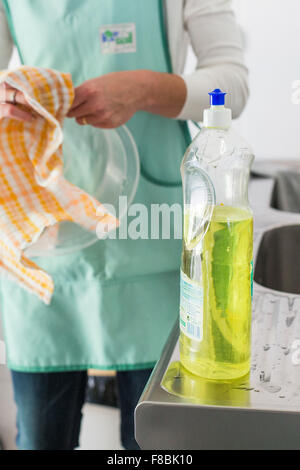 Frau wischte sich die Gerichte. Stockfoto