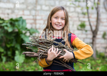 9-Year-Old Girl Brennholz zu sammeln. Stockfoto