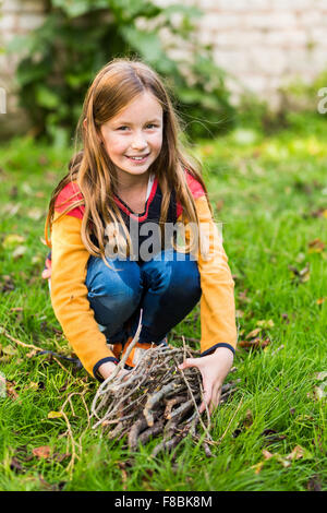 9-Year-Old Girl Brennholz zu sammeln. Stockfoto