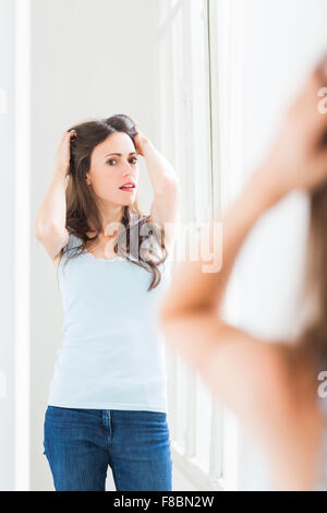 Frau ihr Gesicht im Spiegel zu überprüfen. Stockfoto