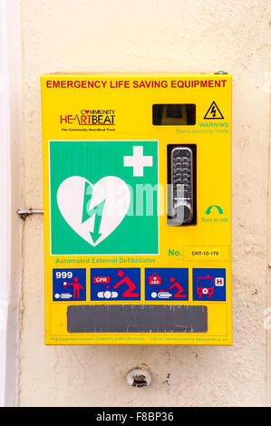 Notfall Leben retten Ausrüstung Defibrillator aus der Community Heartbeat Trust an einer Wand in einer britischen Stadt Stockfoto