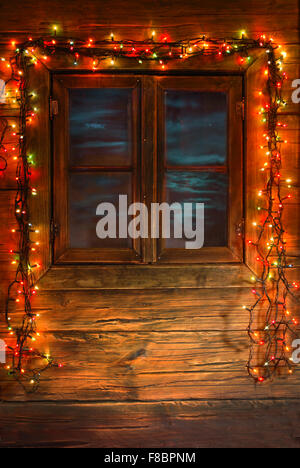 Holzfenster mit bunten Weihnachtsbeleuchtung Stockfoto