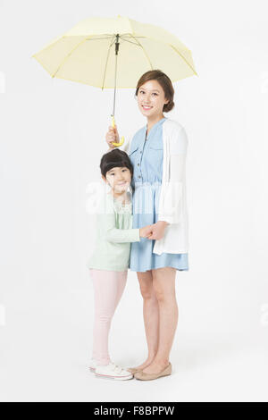 Mutter und Tochter, die Hand in Hand zusammen unter dem Dach, starrte mich mit einem Lächeln Stockfoto