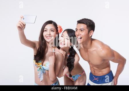 Zwei Frauen im Bikini und ein Mann in die Hose selbst Foto mit einem Smartphone unter schwimmen Stockfoto