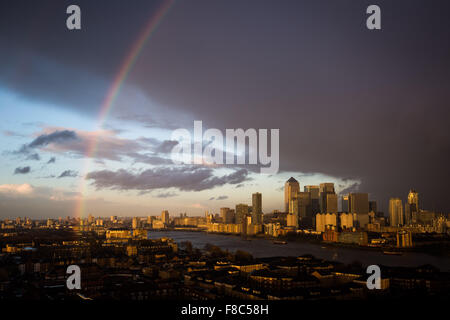 London, UK. 8. Dezember 2015. UK-Wetter: Regenbogen bricht nach Regenschauer über Canary Wharf Geschäftshäuser Park und Fluss Themse Credit: Guy Corbishley/Alamy Live News Stockfoto