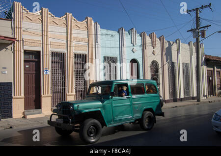 Einen grünen Jeep oder Landrover geht Art Deco Gebäude in Cienfuegos, Kuba, Stockfoto