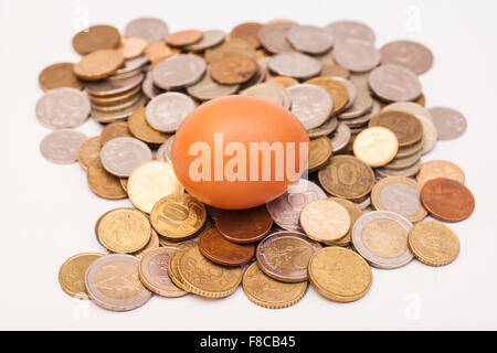 Ei auf liegen und Münzen Stockfoto