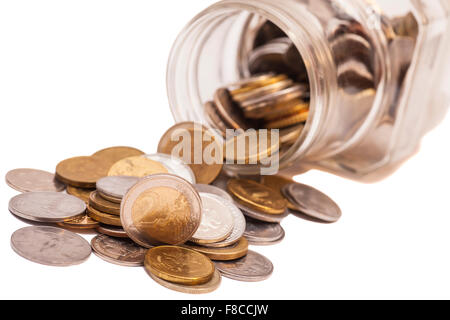 Münzen aus dem Geld-Glas verschütten Stockfoto