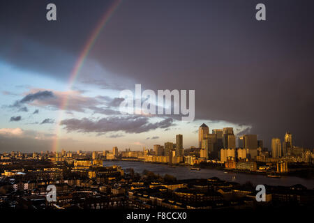 London, UK. 8. Dezember 2015. UK-Wetter: Regenbogen bricht nach Regenschauer über Canary Wharf Geschäftshäuser Park und Fluss Themse Credit: Guy Corbishley/Alamy Live News Stockfoto