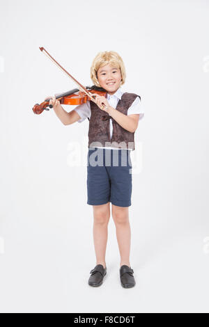 Elementary School Boy im Stil klassischer Musiker stehen und Geige zu spielen Stockfoto