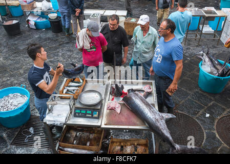 Mann kaufen Fisch, Blick auf die sizilianische Männer in einer Warteschlange Schwertfisch in der Stadt Fischmarkt zu kaufen (Mercato della Pescheria), in Catania, Sizilien. Stockfoto