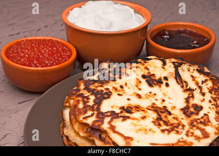 Pfannkuchen und Kaviar, Sauerrahm, Marmelade in den Schalen Stockfoto