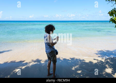 Eine 50 Jahre alte Frau schaut ihr Fotos von der Karibik, St. Croix, Amerikanische Jungferninseln. Stockfoto