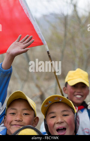 Tibetische Kinder, die spielen mit einer roten Fahne in Tibet Stockfoto