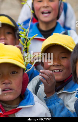 Tibetische Kinder, die spielen mit einer roten Fahne in Tibet Stockfoto