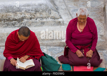 Tibetische Frauen Mönch an der Boudhanath Stupa beten Stockfoto