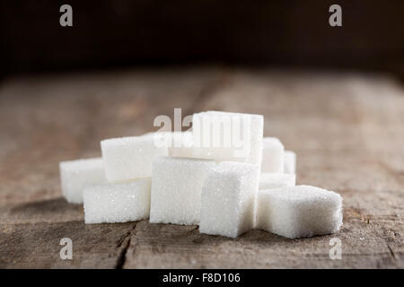 Weiße Zuckerwürfel auf alten Holztisch Stockfoto