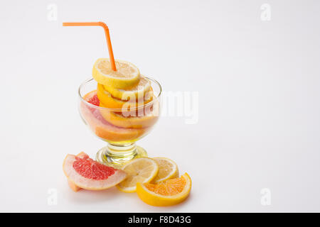 Scheiben von Zitronen-, Orangen- und Grapefruitsaft in einem Glas mit einem Strohhalm in Ihnen Stockfoto