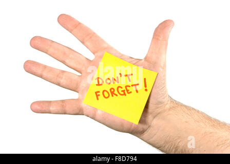 Ausgestreckter Hand mit einem gelben Post-It-Zettel klebte an der Handfläche. Hinweis liest nicht vergessen! in roten Buchstaben. Stockfoto