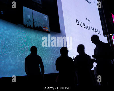 Silhouette des Menschen vor riesigen Digitalanzeige der kommerziellen Werbung in der Dubai Mall, Dubai, Vereinigte Arabische Emirate. Stockfoto