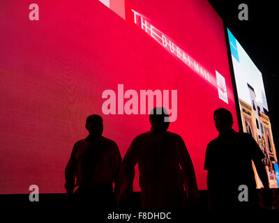 Silhouette des Menschen vor riesigen Digitalanzeige der kommerziellen Werbung in der Dubai Mall, Dubai, Vereinigte Arabische Emirate. Stockfoto