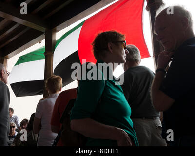 Touristen warten auf Tour bus Abholung unter Flagge der Vereinigten Arabischen Emirate in Dubai, VAE. Stockfoto