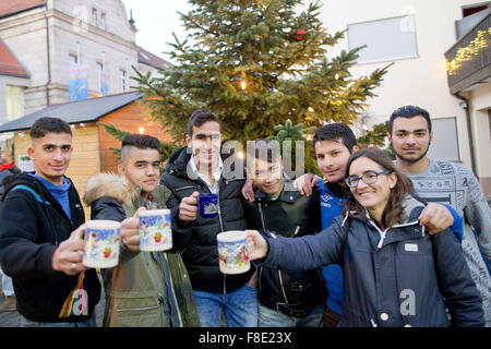 Schnaittach, Deutschland. 6. Dezember 2015. Sofia Wunner (2-R), Leiter der Caritas Wohngruppe für Flüchtlinge in Schnaittach und junge Flüchtlinge von der Anlage trinken Kinderpunsch auf dem Weihnachtsmarkt in Schnaittach, Deutschland, 6. Dezember 2015. Rund 14.500 Jugendliche Flüchtlinge leben im deutschen Bundesland Bayern, nach dem Staatsministerium für Soziales. Die Gruppe in Schnaittach besteht aus neun muslimische Jugendliche zwischen 13 und 17 Jahren aus Syrien, Somalia und Afghanistan. Foto: DANIEL KARMANN/Dpa/Alamy Live News Stockfoto