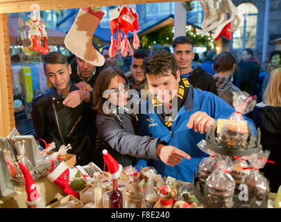 Schnaittach, Deutschland. 6. Dezember 2015. Sofia Wunner (C-L), Leiter der Caritas Wohngruppe für Flüchtlinge in Schnaittach und junge Flüchtlinge der Anlage an einem Stand auf dem Weihnachtsmarkt in Schnaittach, Deutschland, 6. Dezember 2015. Rund 14.500 Jugendliche Flüchtlinge leben im deutschen Bundesland Bayern, nach dem Staatsministerium für Soziales. Die Gruppe in Schnaittach besteht aus neun muslimische Jugendliche zwischen 13 und 17 Jahren aus Syrien, Somalia und Afghanistan. Foto: DANIEL KARMANN/Dpa/Alamy Live News Stockfoto